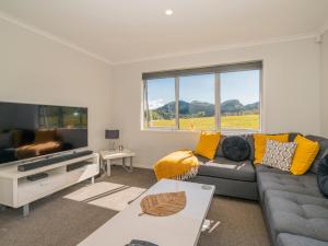 a living room with a couch and a tv at Pauanui Pines - Pauanui Holiday Home in Pauanui