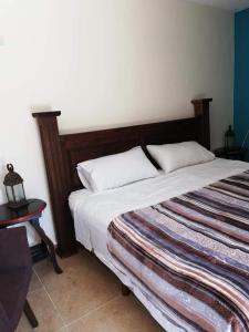 1 cama con 2 almohadas en una habitación en Hacienda Valentina en Playa del Carmen