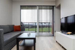 a living room with a couch and a tv and a table at Geirþrúðarhagi one bedroom apartment in Akureyri