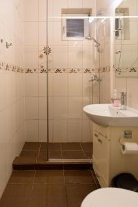 une salle de bains avec douche, lavabo et toilettes dans l'établissement Ultracentral Apartment - "Saint Anthony" Church & Old Town View, à Bucarest
