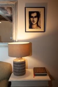 una lampada su un tavolo con un libro e una foto di Popfosters Barn a Weston Subedge