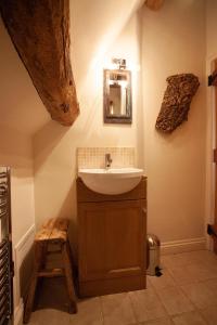 bagno con lavandino e specchio a parete di Popfosters Barn a Weston Subedge