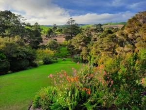 a view of a garden with flowers and trees at Riverside Homestead in Paihia