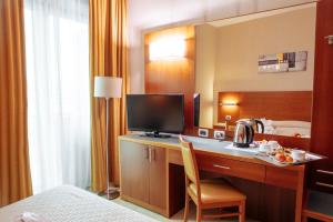 a hotel room with a desk with a television and a bed at Hotel Amico in Citta' Sant'Angelo