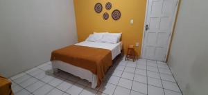 a bedroom with a bed and a yellow wall at Z-18 Hostel in Barreirinhas