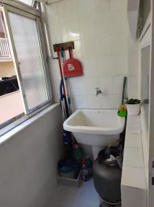 a small bathroom with a sink and a tub at Studioaconchegantepoa in Porto Alegre