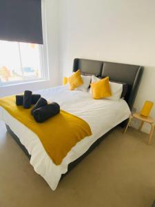 a bed with yellow pillows and a yellow blanket at Seascape Scarborough Stunning Seaview Holiday Home Apartment in Scarborough