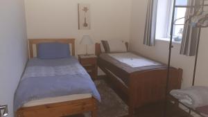 a small bedroom with two beds and a window at Esker House in Donegal