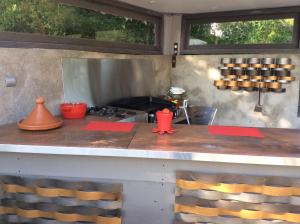 cocina con fogones y mesa con sillas en La Parenthèse, en Montluçon