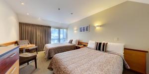 Habitación de hotel con 2 camas y escritorio en Dunedin Leisure Lodge - Distinction en Dunedin