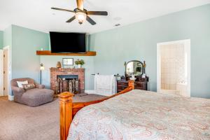 a bedroom with a bed and a tv and a fireplace at Farmhouse Family Getaway in Pismo Beach