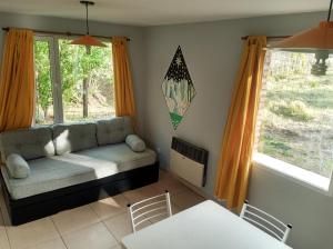 a living room with a couch and two windows at Flamenco Bay Apartments in El Calafate