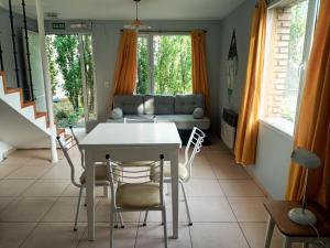 uma sala de estar com uma mesa e cadeiras e um sofá em Flamenco Bay Apartments em El Calafate