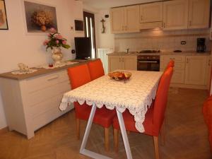 Castelveccana的住宿－Casa Rondinelle，厨房配有带橙色椅子的桌子和柜台。