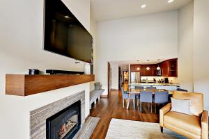 a living room with a fireplace and a tv on a wall at The Seasons at Avon in Avon