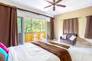 een slaapkamer met een bed, een stoel en een raam bij Downtown Suites in Boquete