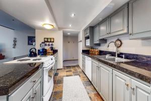 una cocina con armarios blancos y fregadero en Stonebridge Valley View en Park City