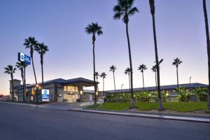 a building with palm trees in front of a street at Best Western Kettleman City Inn & Suites in Kettleman City
