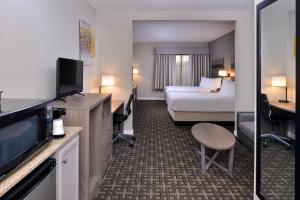 a hotel room with a bedroom with a bed and a television at Best Western Kettleman City Inn & Suites in Kettleman City +40 photos