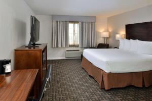 a hotel room with a bed and a flat screen tv at Best Western Kettleman City Inn & Suites in Kettleman City