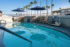 a swimming pool with chairs and umbrellas on a resort at Best Western Kettleman City Inn & Suites in Kettleman City
