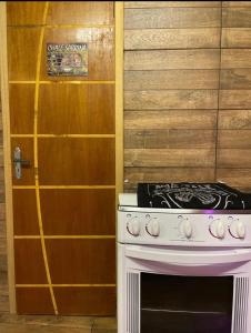 a white stove in a kitchen with a door at Chale Sabrina in Campos do Jordão