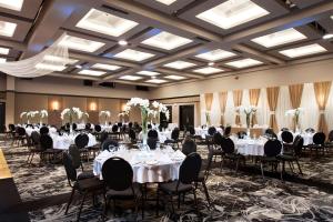 - une salle de banquet avec des tables et des chaises blanches dans l'établissement Best Western Hotel Universel Drummondville, à Drummondville