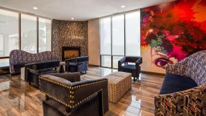 a living room filled with furniture and a painting on the wall at Best Western Plus Executive Residency Denver-Central Park Hotel in Denver