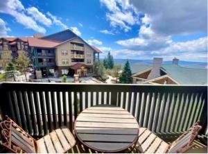 a deck with a table and chairs on a balcony at *APRES SKI LODGE, SKI IN-SKI OUT, CENTRAL VILLAGE! in Snowshoe