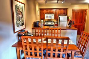 a kitchen with a table with chairs and a refrigerator at *APRES SKI LODGE, SKI IN-SKI OUT, CENTRAL VILLAGE! in Snowshoe