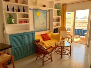 uma sala de estar com um sofá, cadeiras e uma mesa em Apartments Pepe, Es Pujols-Formentera vacaciones em Es Pujols