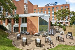 a patio with tables and chairs in front of a hotel at Radisson Blu Hotel Karlsruhe in Ettlingen
