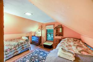 a attic bedroom with two beds and a window at Hudson Riverside Cottage in Chestertown