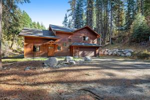 a log cabin in the woods with trees at Rivers Edge Retreat in McCall