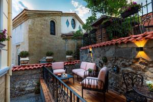 a patio with pink chairs and a building at Gallery 37 Powered by ASTON in Plovdiv