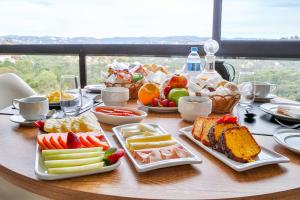 une table recouverte de assiettes de nourriture et de fruits dans l'établissement Carpe Diem Boutique & Spa - BW Premier Collection, à Campos do Jordão