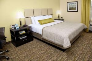 a hotel room with a large bed and a night stand at Sonesta Simply Suites Fort Worth in Fort Worth