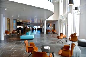 a lobby with chairs and tables in a building at Best Western Plus Hotel Ilulissat in Ilulissat
