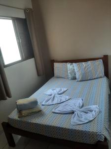 - un lit avec des serviettes et une fenêtre dans l'établissement HOTEL LAYANE VITORIA, à Cambuí