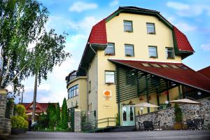 a large yellow building with a red roof at Hotel Restaurant Park in Miercurea-Ciuc