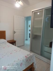 um quarto com uma cabina de duche em vidro e uma cama em Residencial Simas em Florianópolis