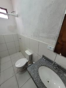 a white bathroom with a toilet and a sink at Hotel Buriti in Carolina