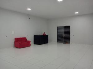 a red chair sitting in a white room at Hotel Buriti in Carolina