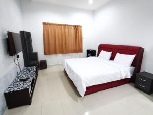 ein Schlafzimmer mit einem Bett und einem Fernseher darin in der Unterkunft SingLeisure Holiday House in Mersing + 29 Fotos
