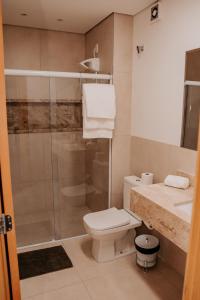 a bathroom with a shower and a toilet and a sink at Apartamento Le Onze Centro in Monte Verde +14 photos