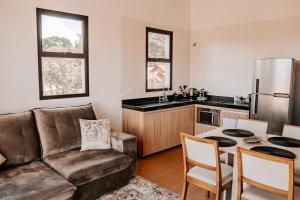 a living room with a couch and a table in a kitchen at Apartamento Le Onze Centro in Monte Verde