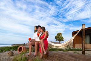 a man and a woman sitting on a beach at Norte Suites Boutique in Los Órganos