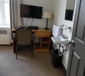 a hotel room with a desk and a sink at Gîte le 812 in Quebec City