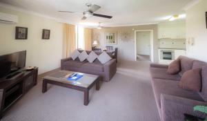 sala de estar con 2 sofás y TV en Aussie Resort, en Gold Coast