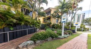 una casa con una valla y una acera de ladrillo en Aussie Resort en Gold Coast